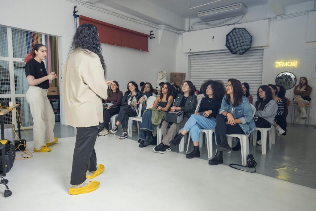 Group of diverse adults attending an indoor creative workshop, listening attentively.