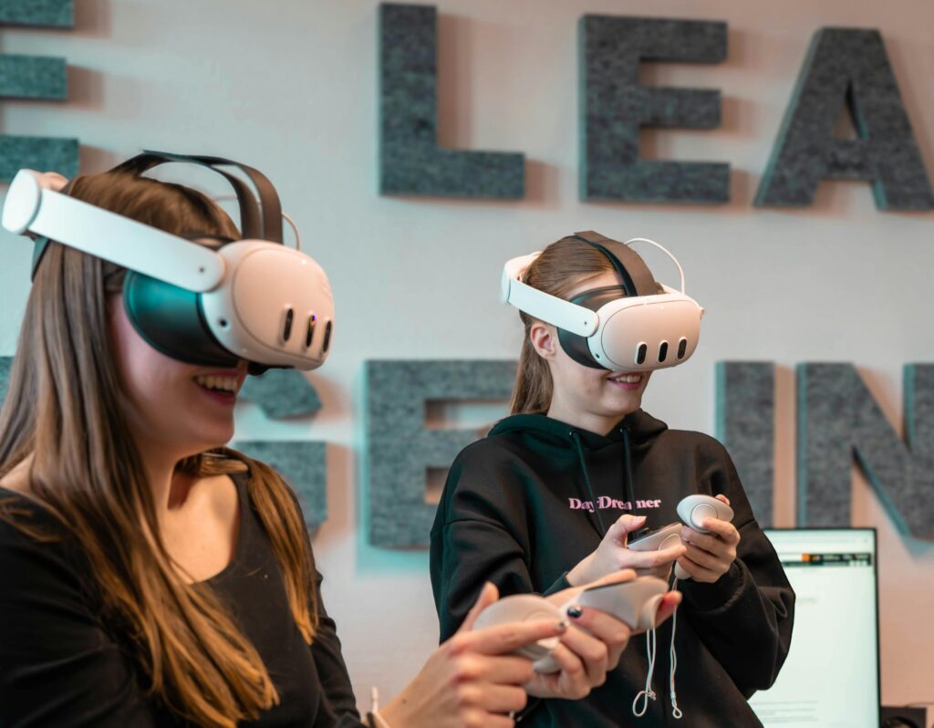 Two women engaged in an immersive virtual reality gaming experience indoors.